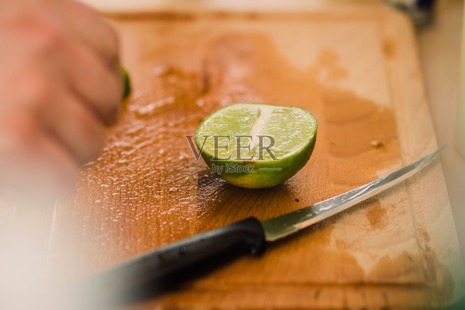 一个对半切开的酸橙和一把放在木板上的刀的特写镜头照片摄影图片
