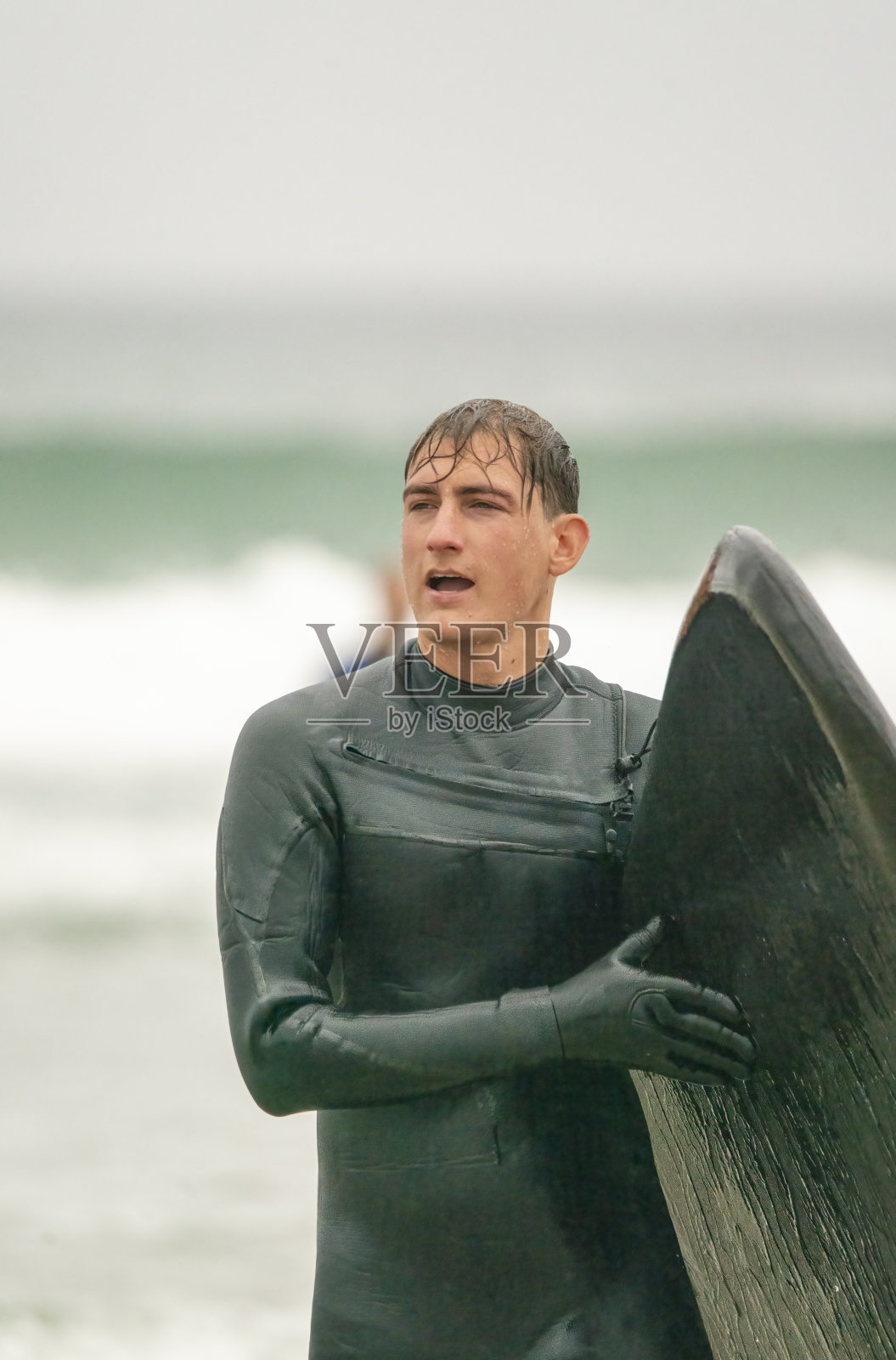 一个年轻人在康沃尔海岸冲浪后离开了水面照片摄影图片