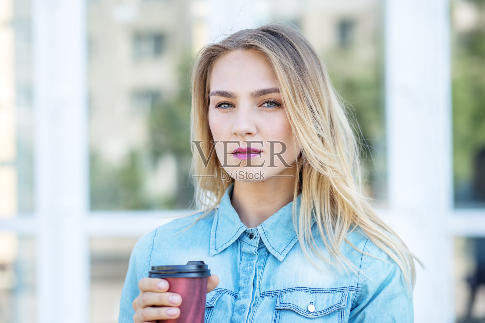 年轻严肃的女人端着咖啡。生活方式的概念，都市，青年。照片摄影图片