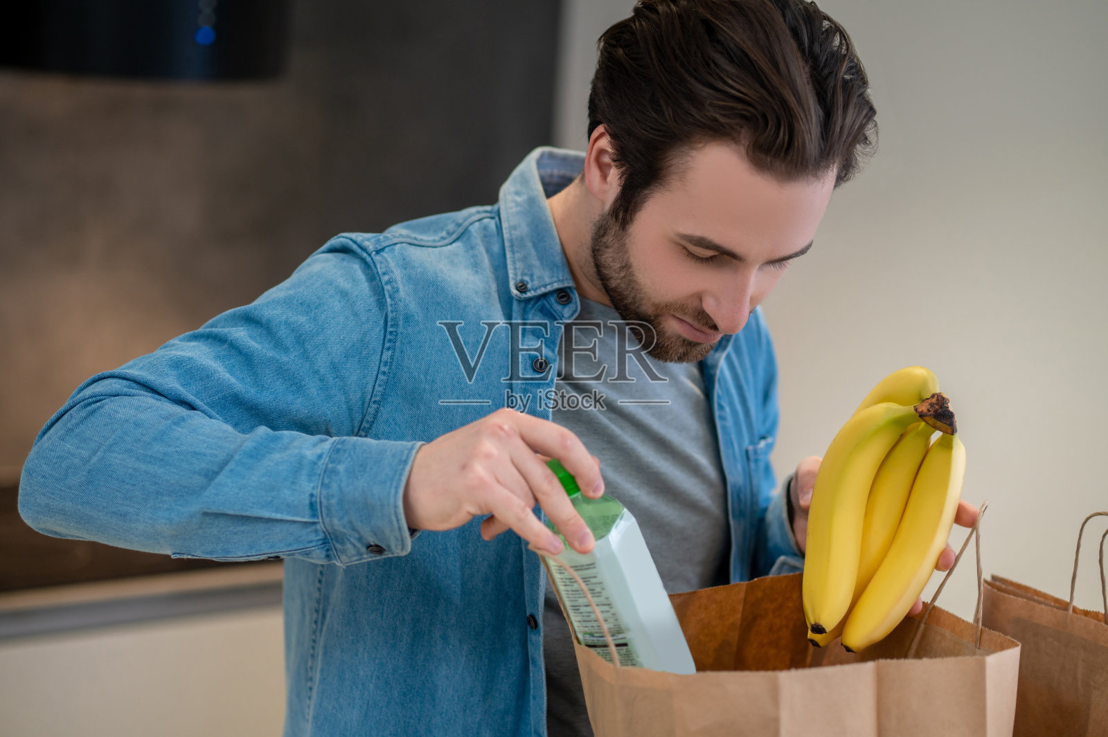 拿着水和香蕉窥视袋子的人照片摄影图片