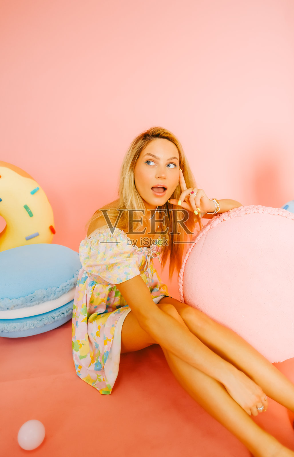 有吸引力的白人女性时尚模特与金发的肖像，在粉红色的背景与数字的糖果。照片摄影图片