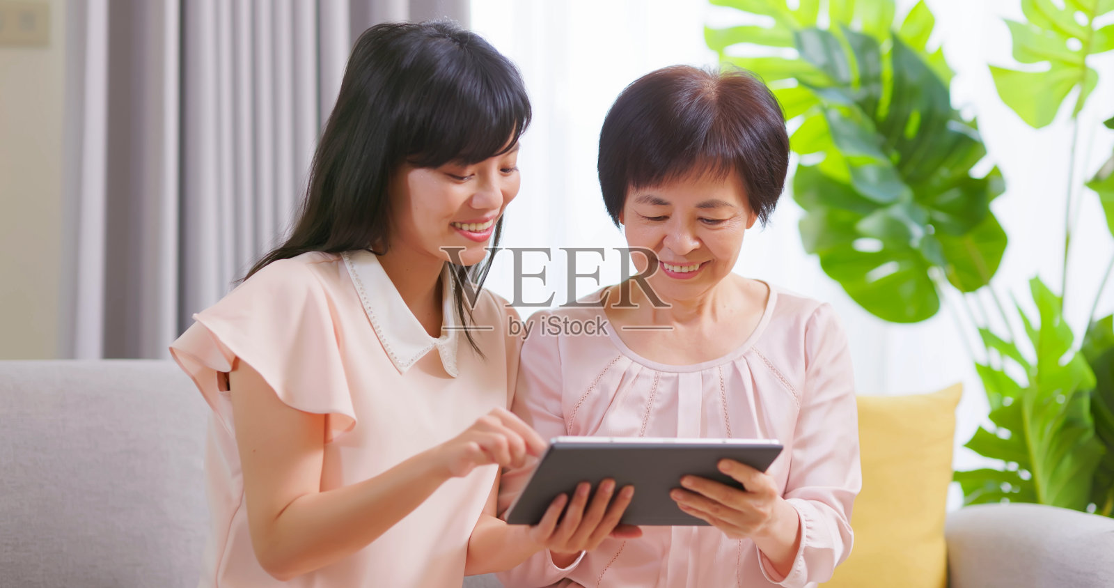 女儿给妈妈看平板电脑照片摄影图片