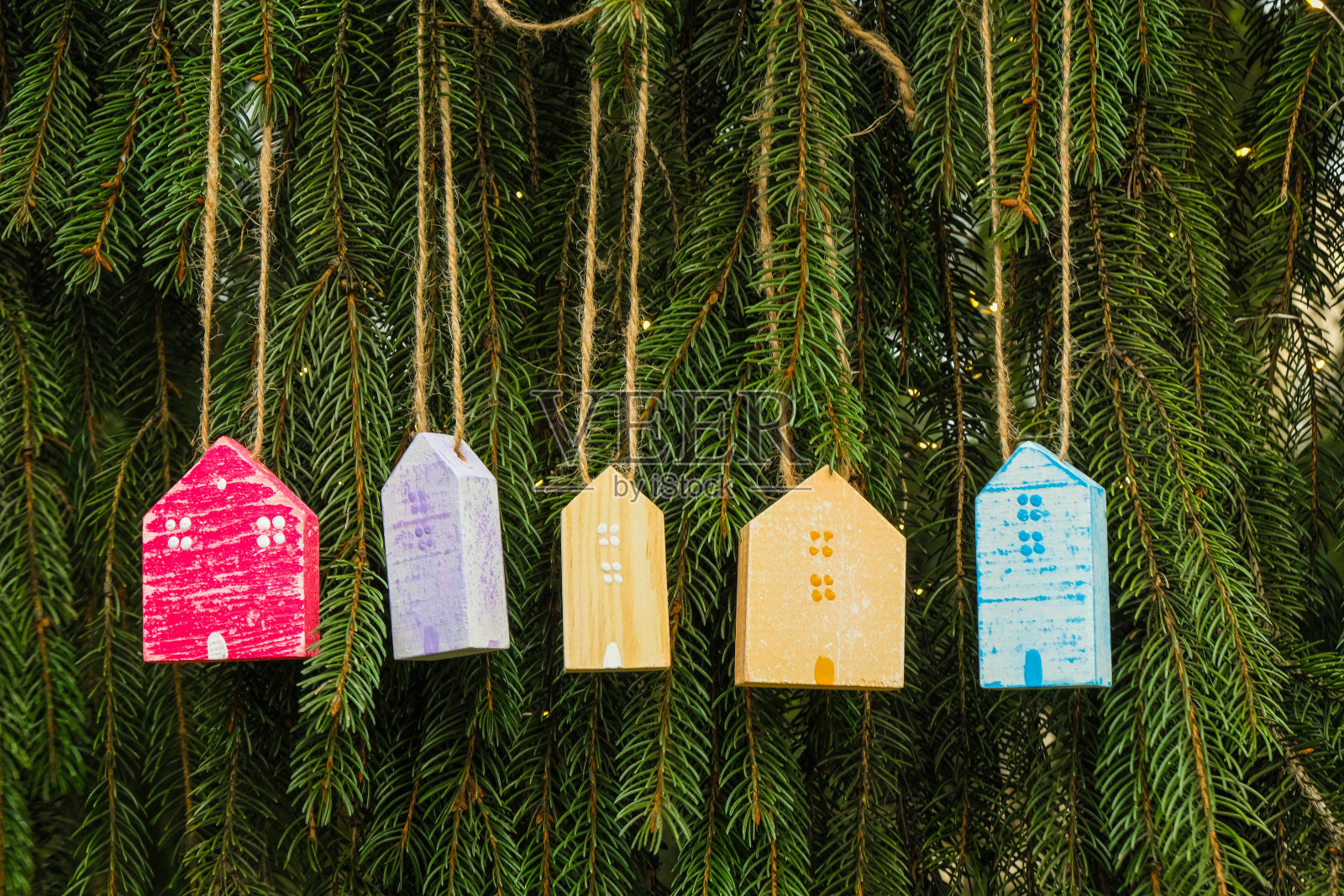 云杉背景上的彩色木屋。房地产圣诞大甩卖。照片摄影图片