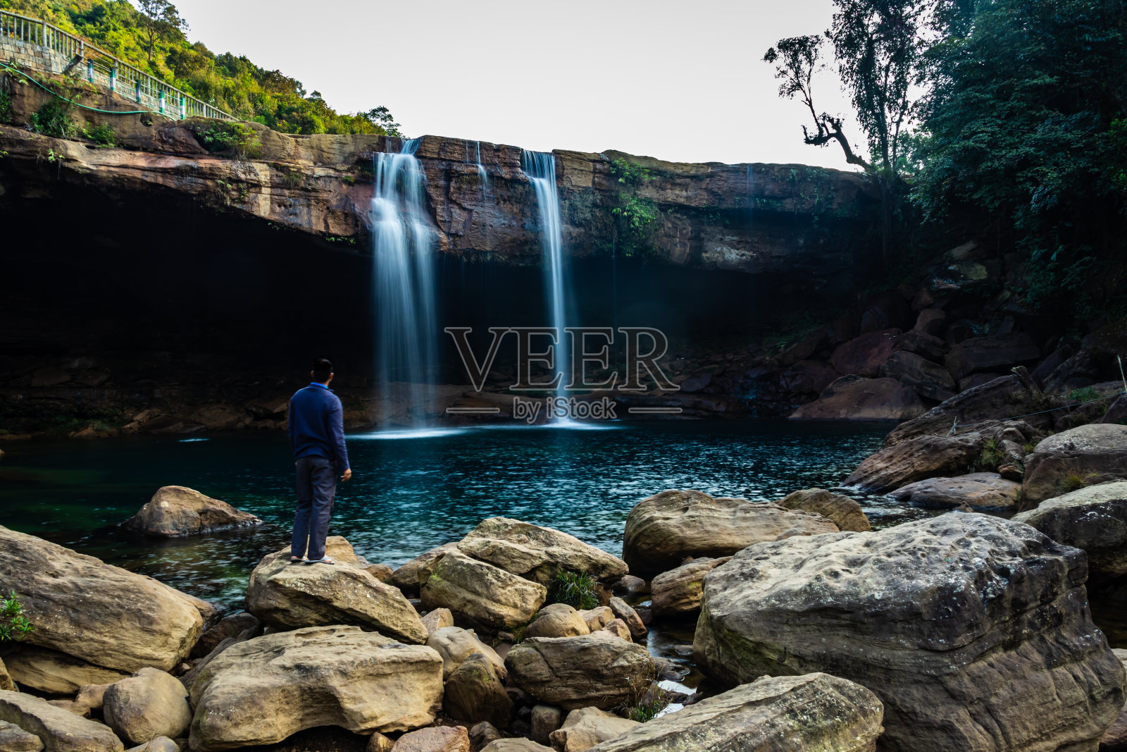 年轻人与瀑布溪流从山顶在早晨长曝光拍摄照片摄影图片