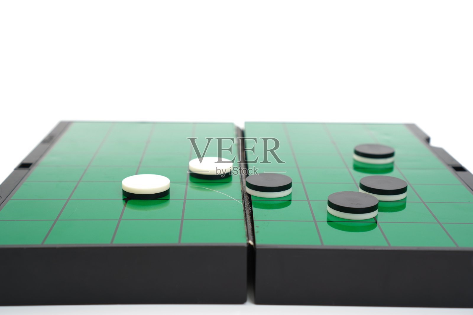 这张照片展示的是在白色和黑色棋盘之间玩西洋跳棋的示范。照片摄影图片