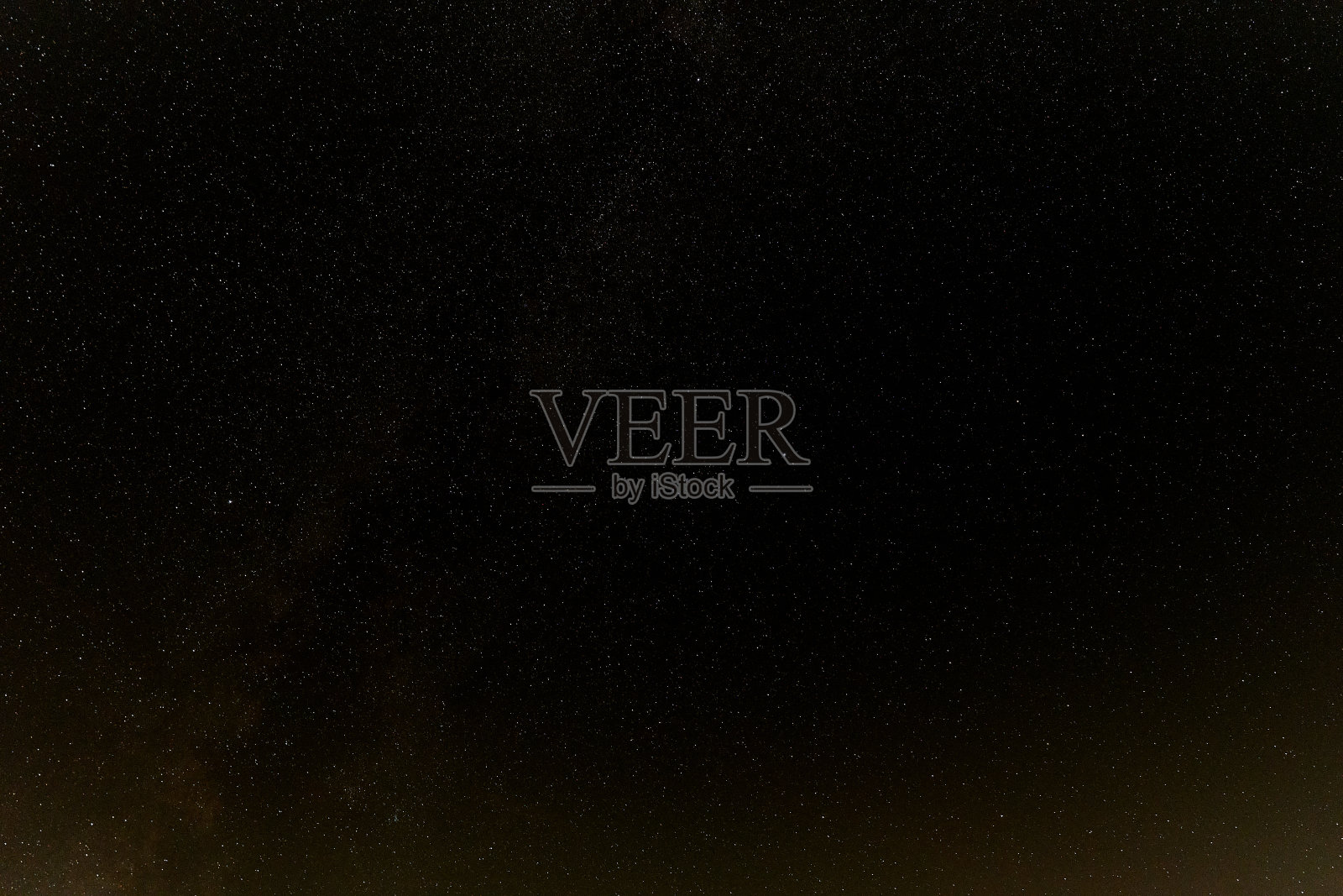 黑色的夜空中有许多小星星，图片的下边缘闪烁着橙色的微光。德国。照片摄影图片