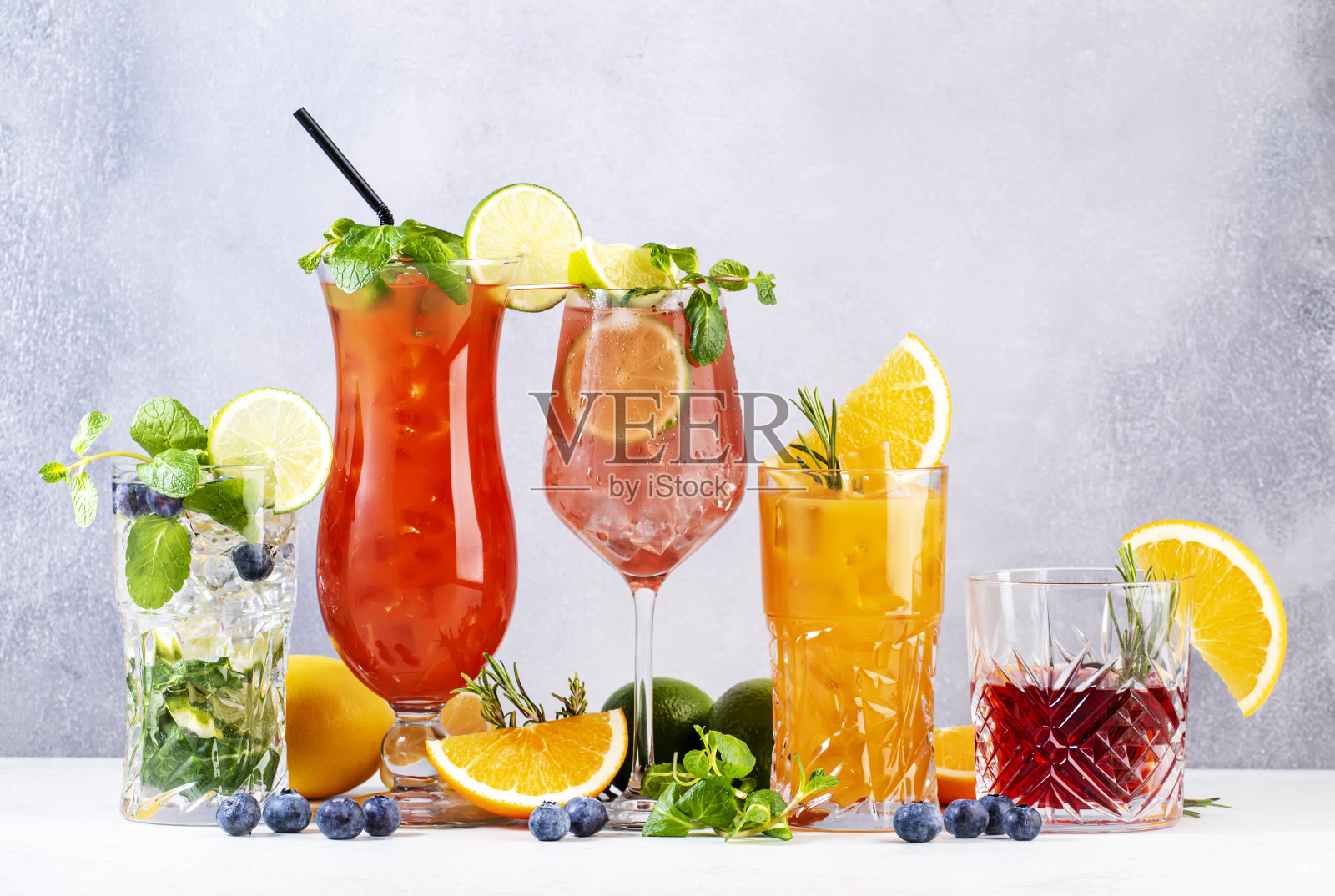 时髦的夏日鸡尾酒集:内格罗尼，蓝莓莫吉托，螺丝刀，飓风和法国骡子在灰色吧台背景照片摄影图片