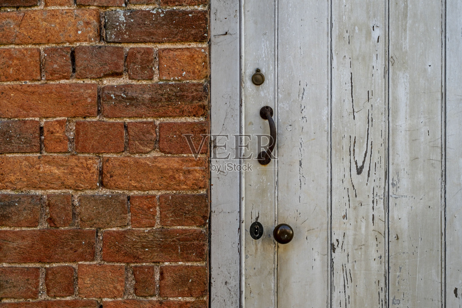 在英国德文郡托普舍姆，旧红砖墙旁的白色木门照片摄影图片