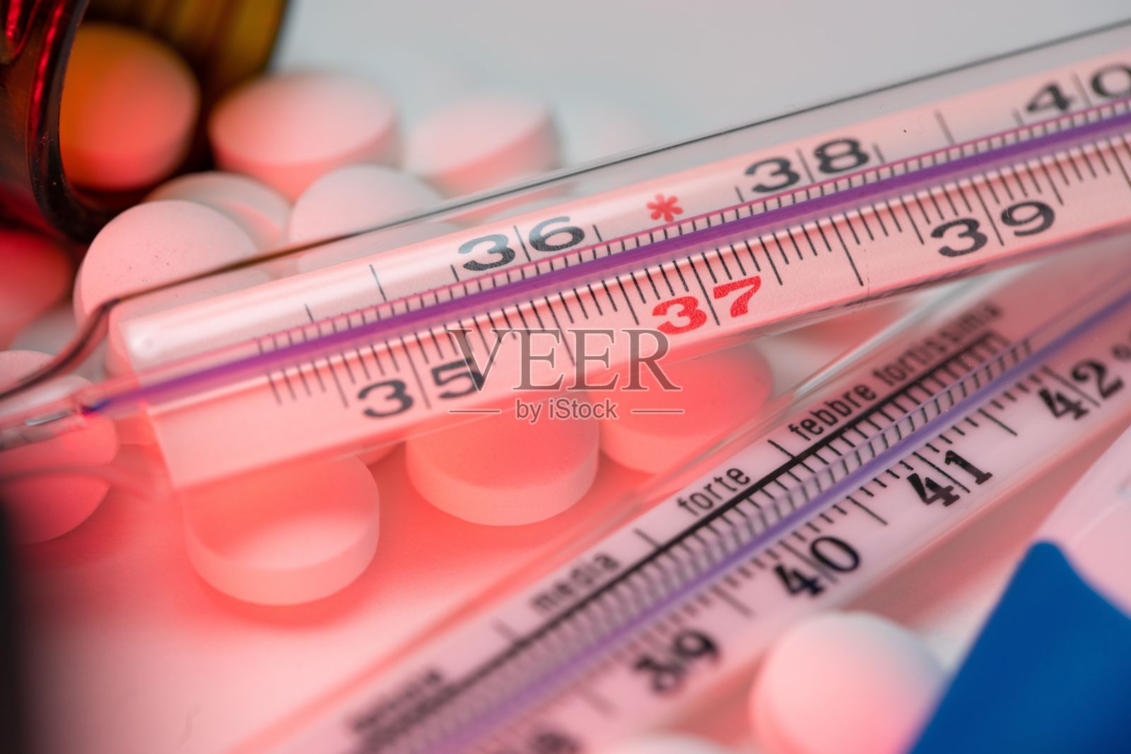 药丸和药物的特写与临床发热温度计在白色背景照片摄影图片