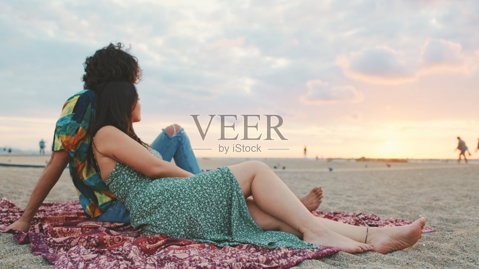 热恋中的情侣在海滩上欣赏美丽的日出美景照片摄影图片