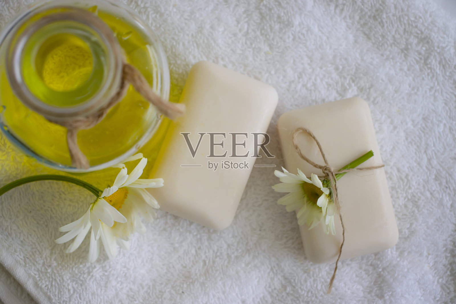 天然肥皂，洋甘菊花在浅色的背景上照片摄影图片