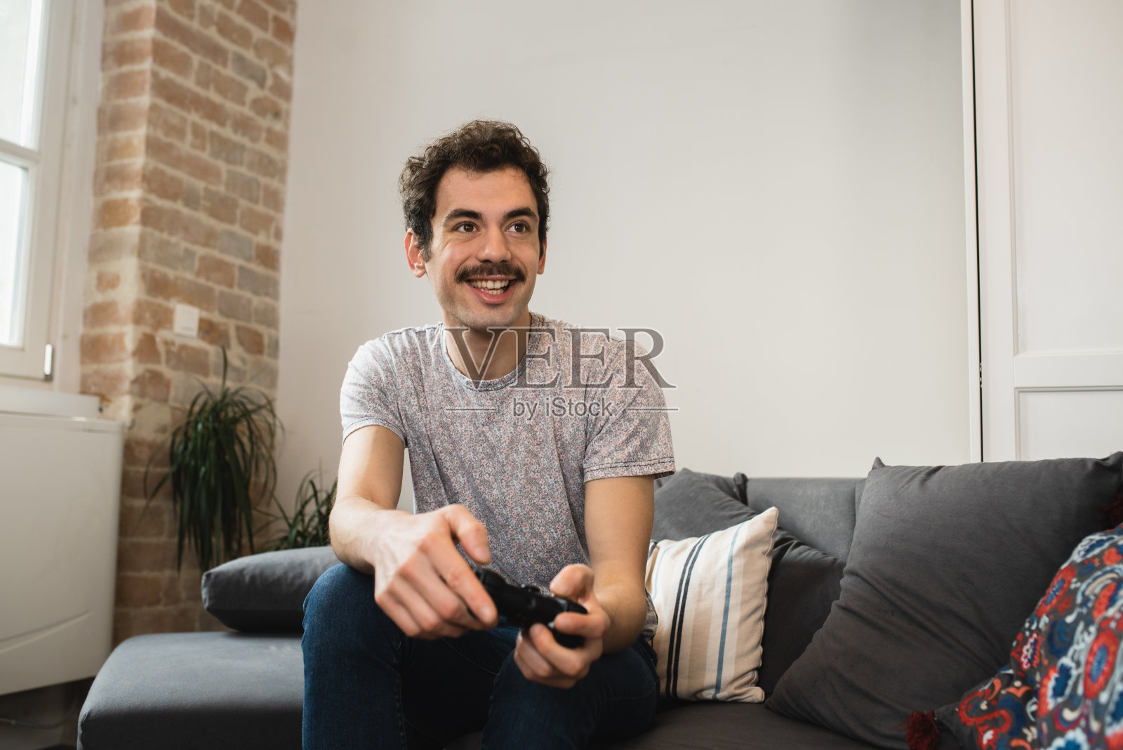 一个年轻人的肖像正在玩电子游戏照片摄影图片