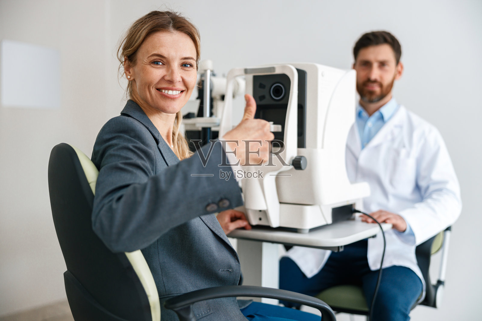 妇女在眼科诊所检查视力后对结果满意照片摄影图片