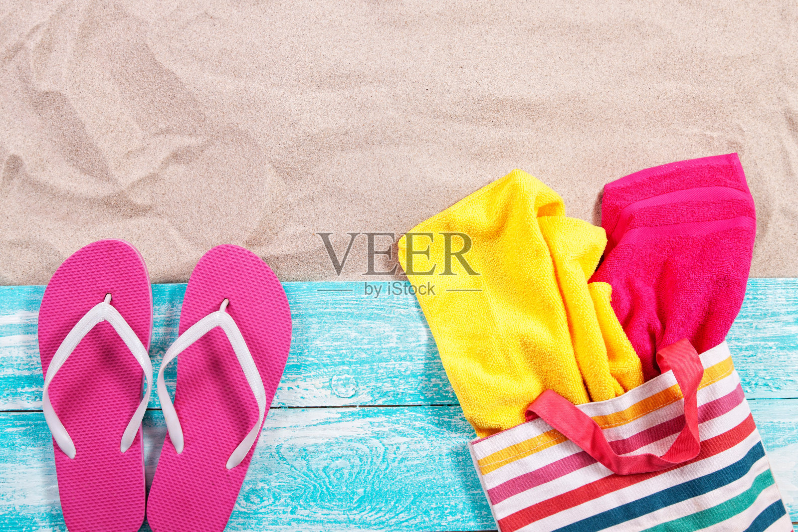 砂复制空间。沙背景俯视图。沙滩巾装在沙滩包里，沙滩拖鞋照片摄影图片