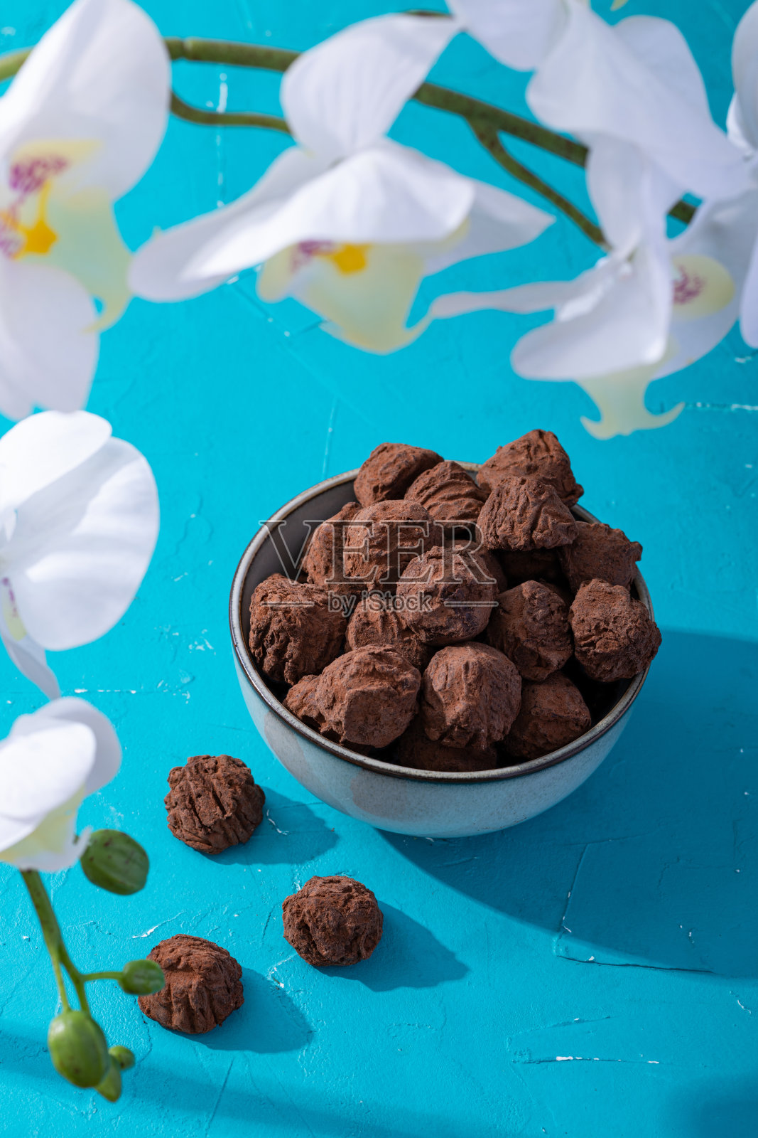 手工制作的乡村巧克力松露，绿松石上有白色兰花照片摄影图片