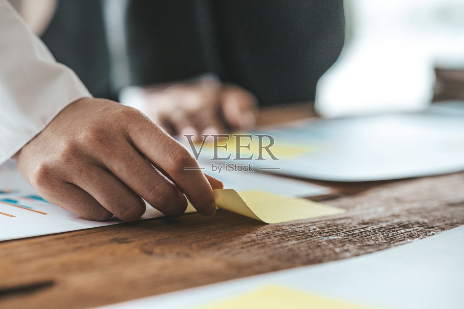 女商人在她的办公桌上拿着记事本，一群商人参加会议，举行会议材料，头脑风暴会议，计划公司的发展。商务会议的想法。照片摄影图片