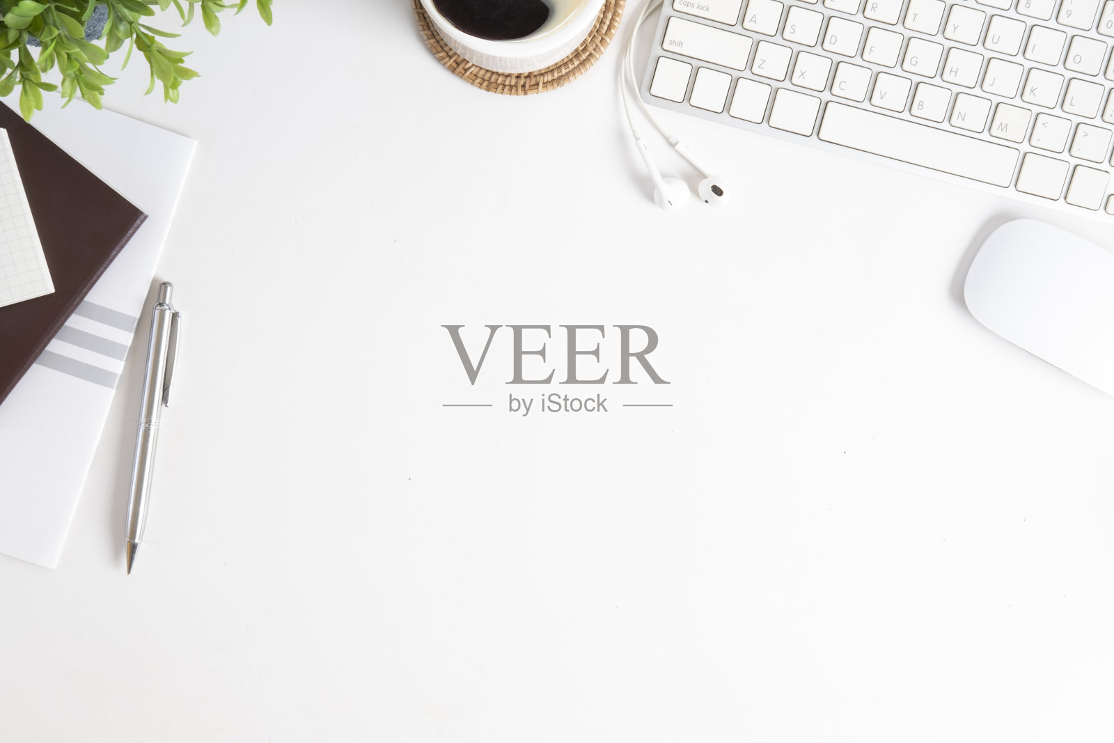 白色办公桌，键盘，盆栽，咖啡杯和供应商。带有复制空间的俯视图。照片摄影图片