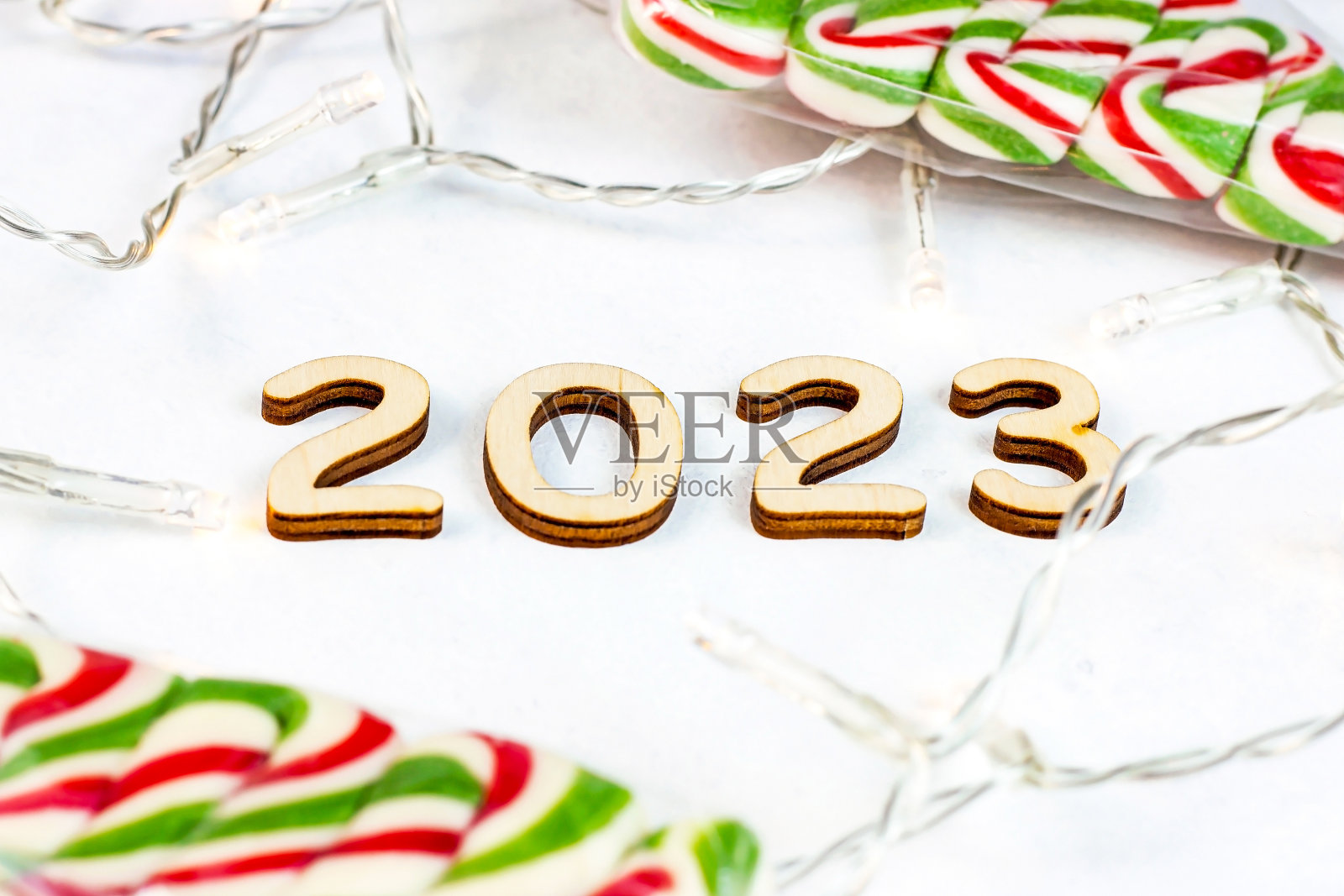 木制数字2023剪影与圣诞灯和糖果的光背景。新年伊始恭喜和规划概念照片摄影图片