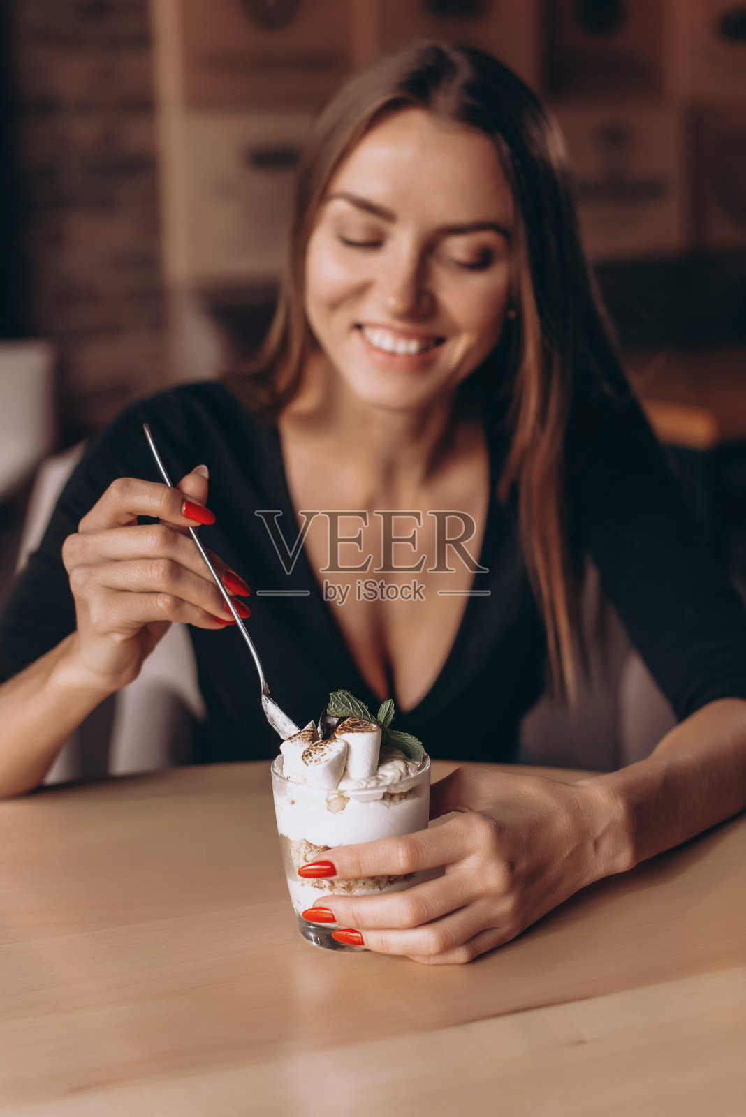 品尝巧克力布朗尼蛋糕奶昔的微笑女人照片摄影图片