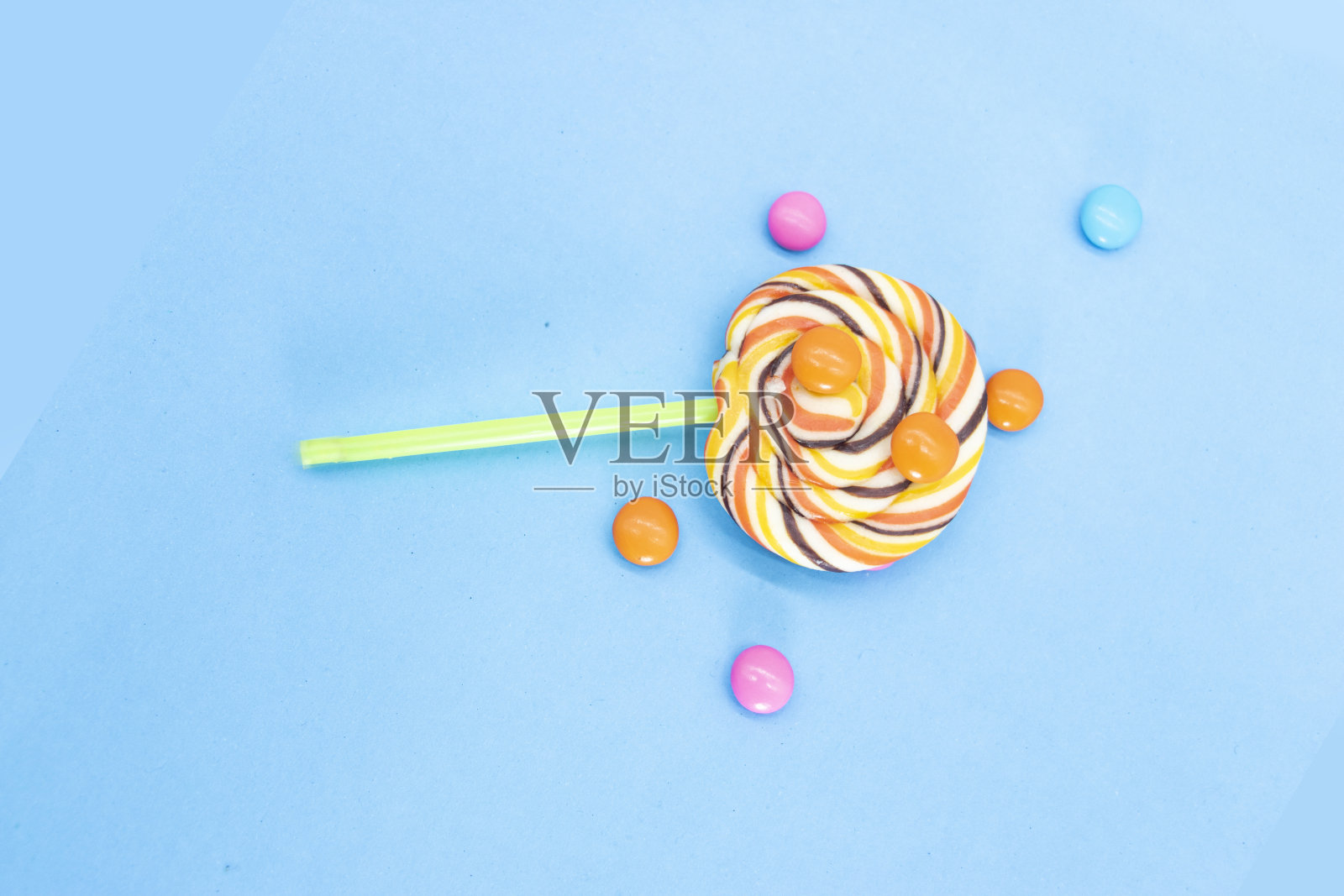 彩色棒棒糖与糖果药丸孤立的蓝色背景照片摄影图片