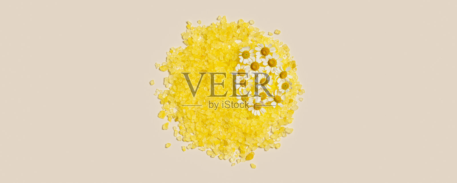 沐浴盐海与草药提取洋甘菊，堆天然海盐晶体黄色和花朵。芳香疗法和草药水疗宽横幅，身体护理化妆品的概念照片摄影图片