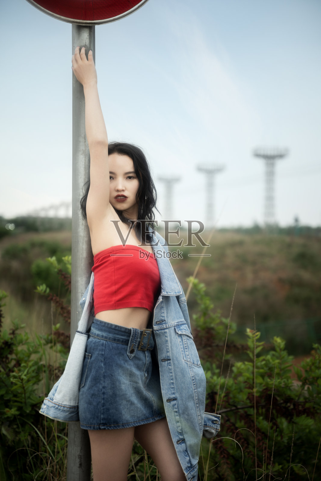 穿着红衣服的时髦女人站在路上照片摄影图片