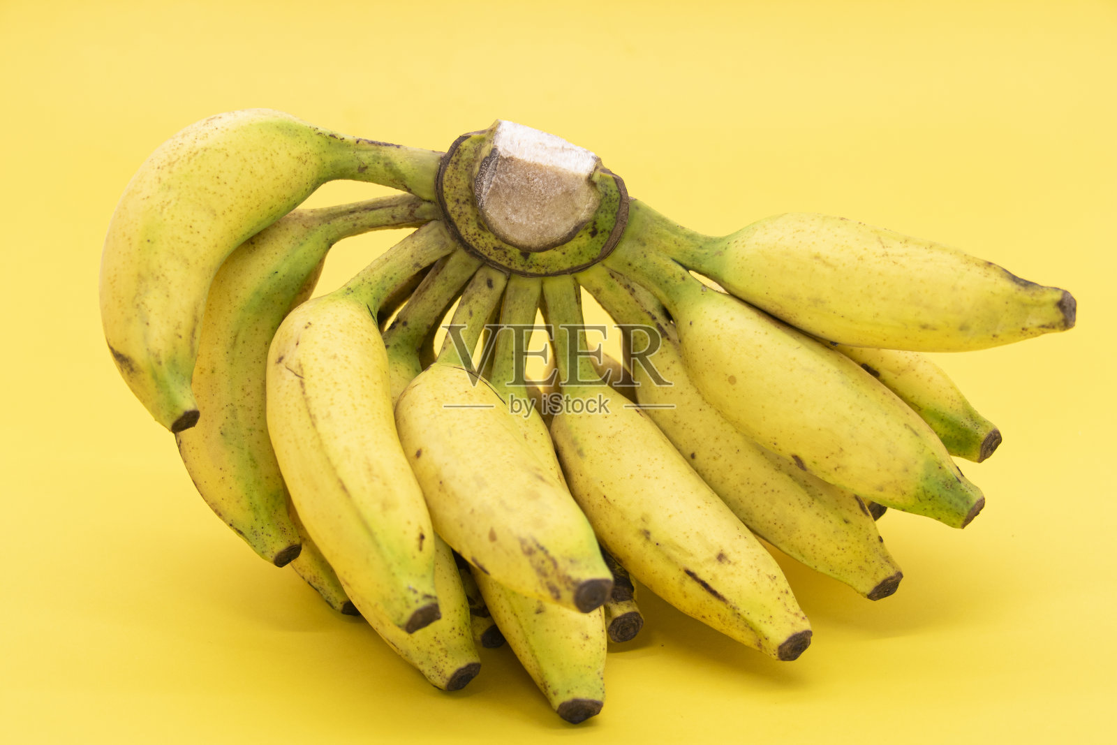 一串香蕉孤立在黄色背景照片摄影图片