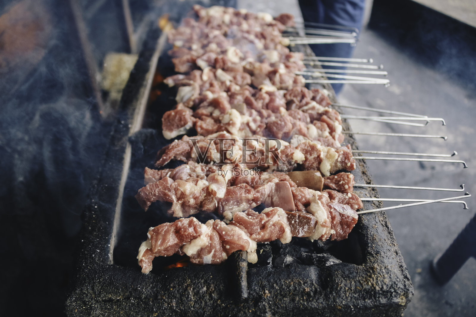 在木炭烤架上制作生山羊肉沙爹。照片摄影图片