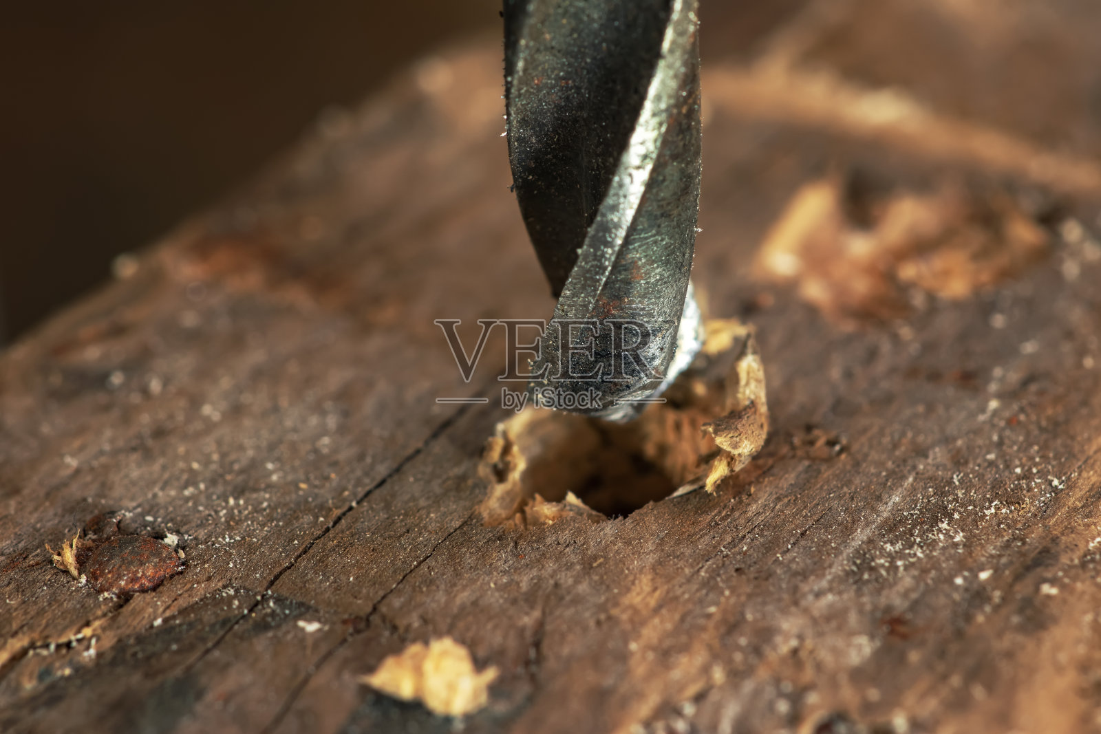 金属钻头在橡木板上打孔照片摄影图片