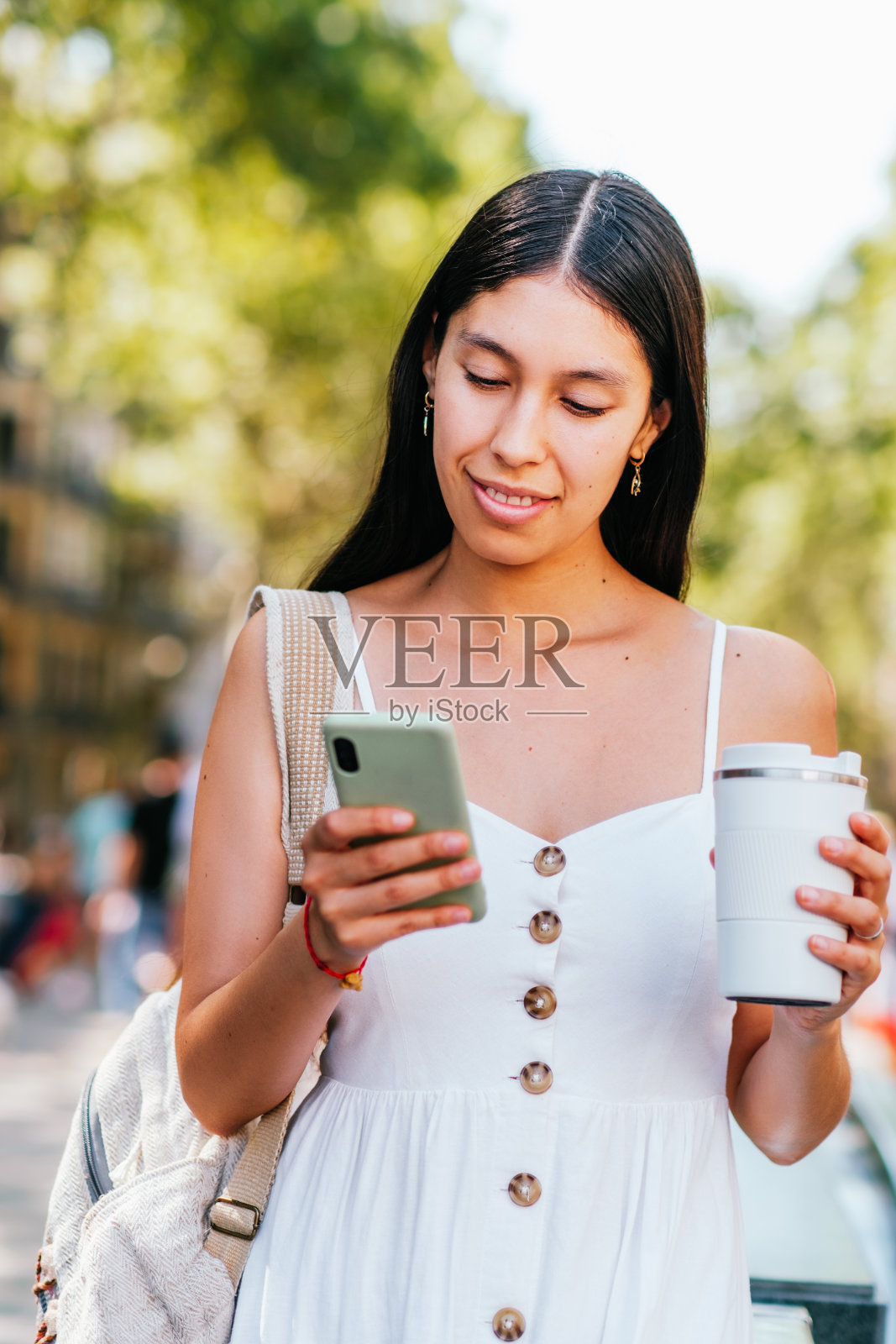 用智能手机喝咖啡的西班牙女子照片摄影图片