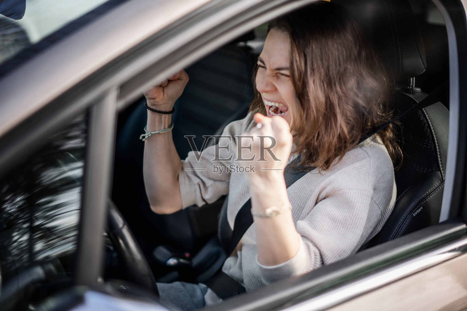 一个年轻漂亮的女人坐在驾驶座上的情感表达照片摄影图片