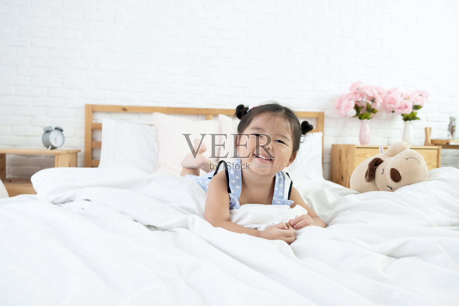 可爱的亚洲女孩躺在床上微笑的脸照片摄影图片