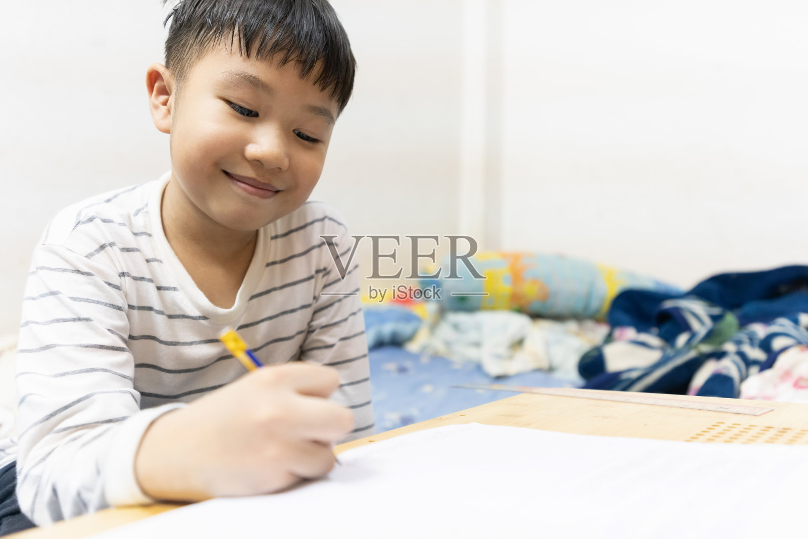 家庭、学校和新的正常生活方式观念。亚洲男孩通过网络媒体学习，在家做作业，因为社会距离政策，以防止新冠病毒的传播照片摄影图片