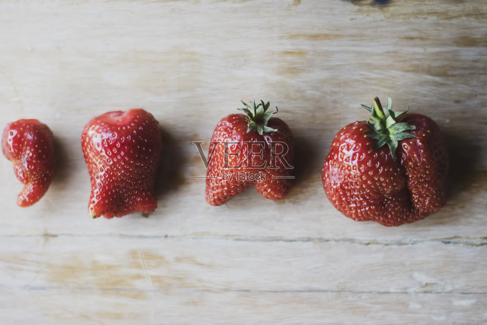 奇怪有趣不完美的新鲜多汁草莓，不寻常的有机草莓，时髦丑陋的食物，选择性重点照片摄影图片