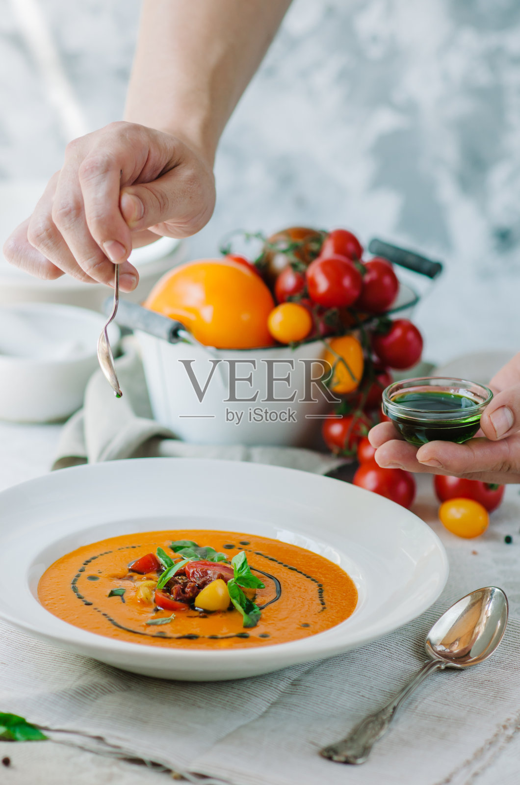美味的香草奶油番茄汤。夏天淡黄色的番茄汤。厨师在这道菜的装饰上加了一片罗勒叶照片摄影图片