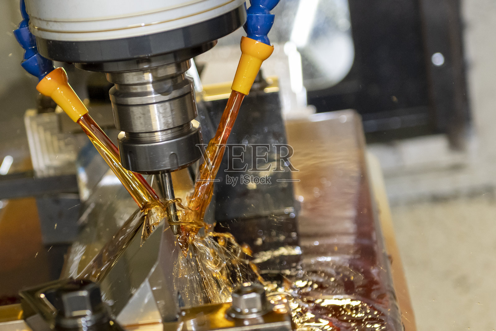 数控铣床采用油冷却法切割模具零件。照片摄影图片