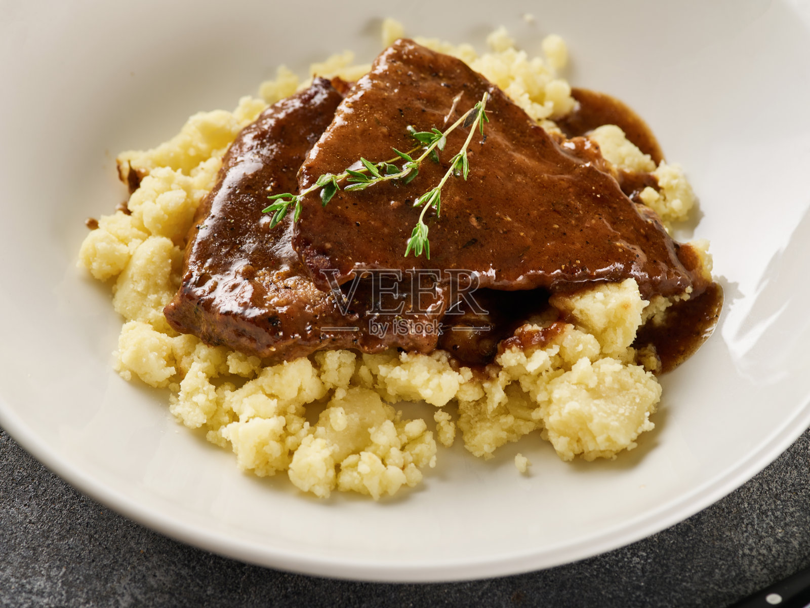 近景切片烤牛肉与土豆泥在盘子上的灰色背景照片摄影图片