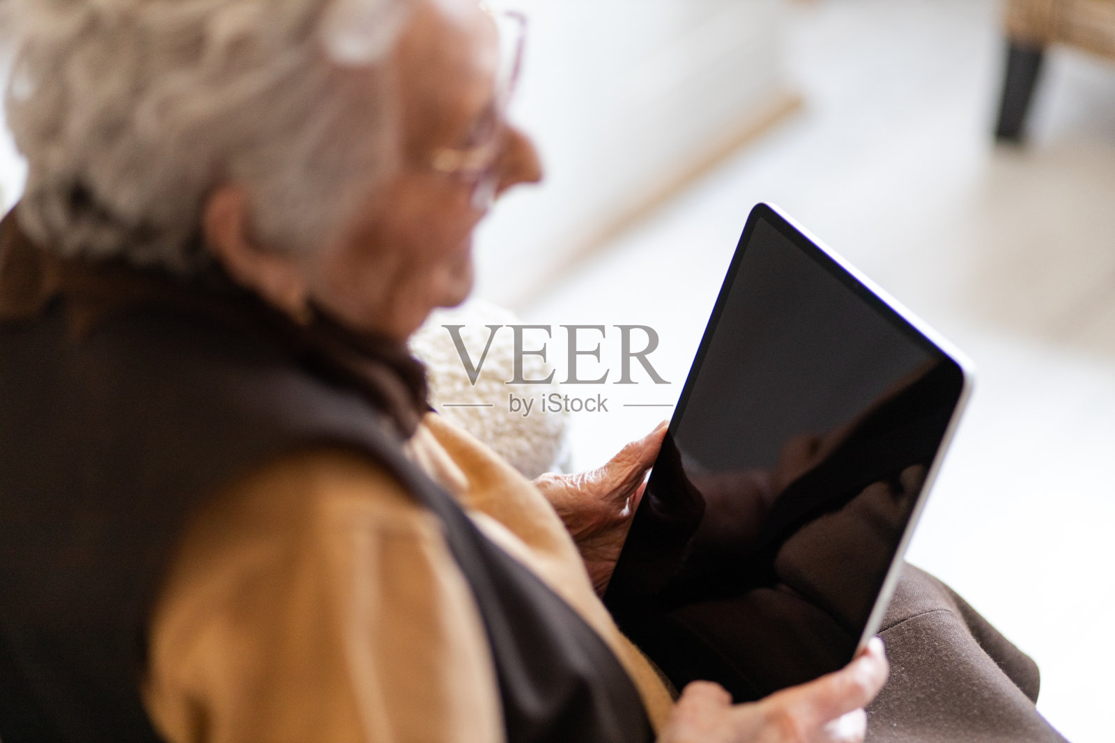 特写奶奶在家里用平板电脑- iPad照片摄影图片