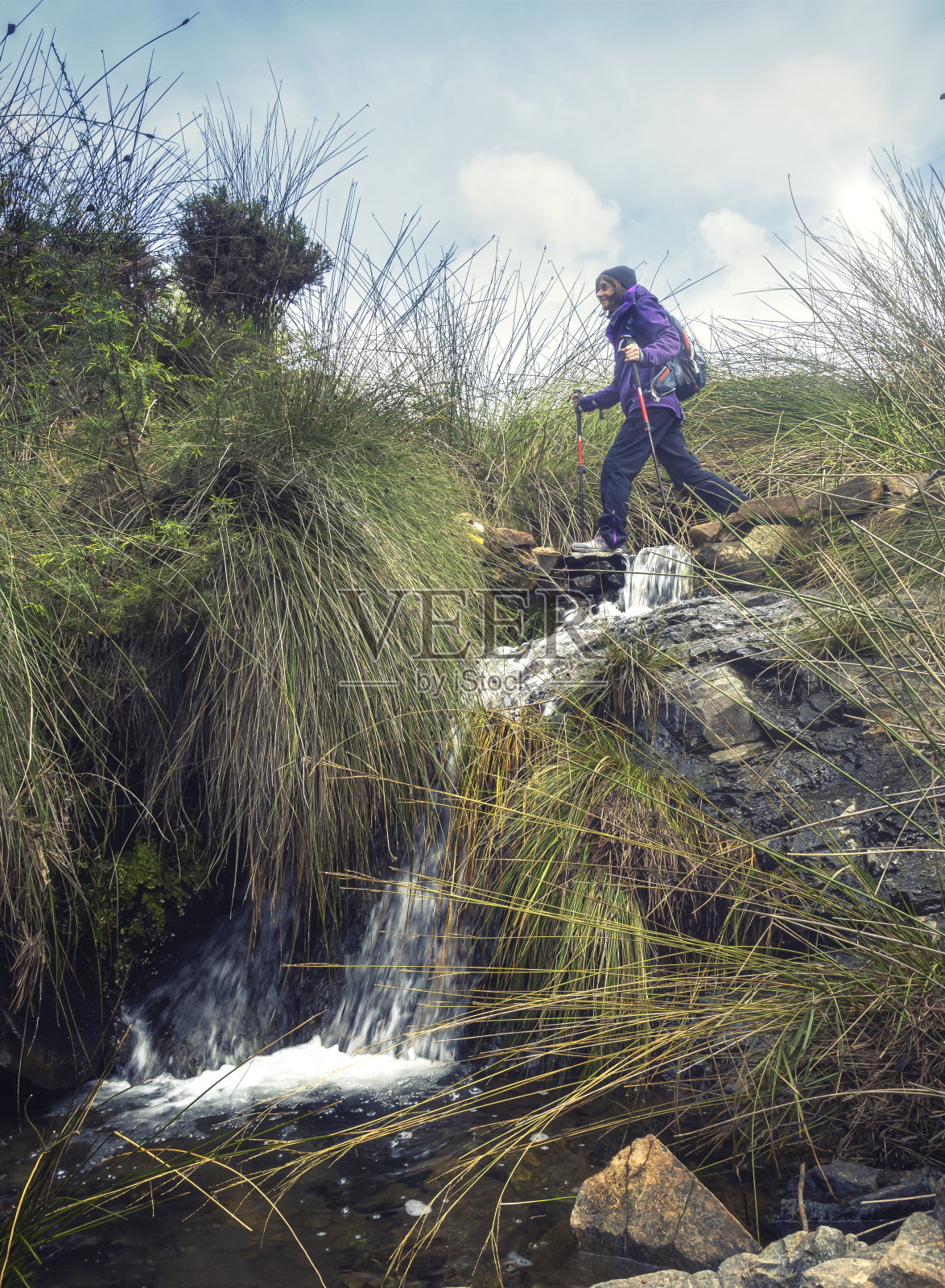 一个女人独自徒步穿越一条小溪照片摄影图片