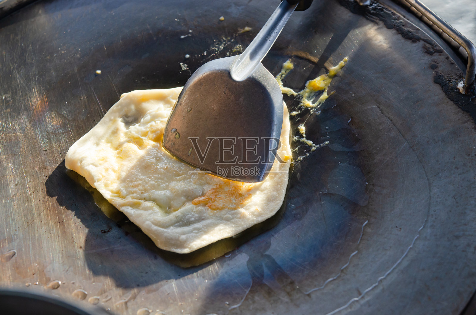 在阳光下，在平底锅里煎鸡蛋的烤饼。照片摄影图片