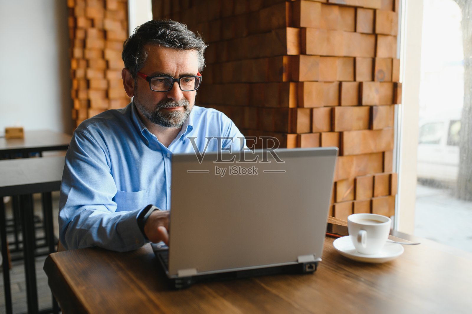 商业，技术和人的概念，高级商人与笔记本电脑在现代咖啡馆喝咖啡。照片摄影图片