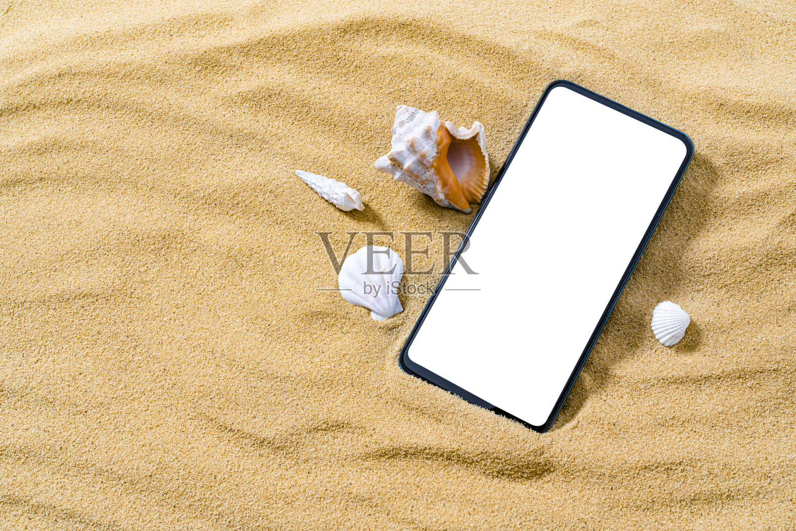 手机躺在金色的沙滩上。本空间照片摄影图片