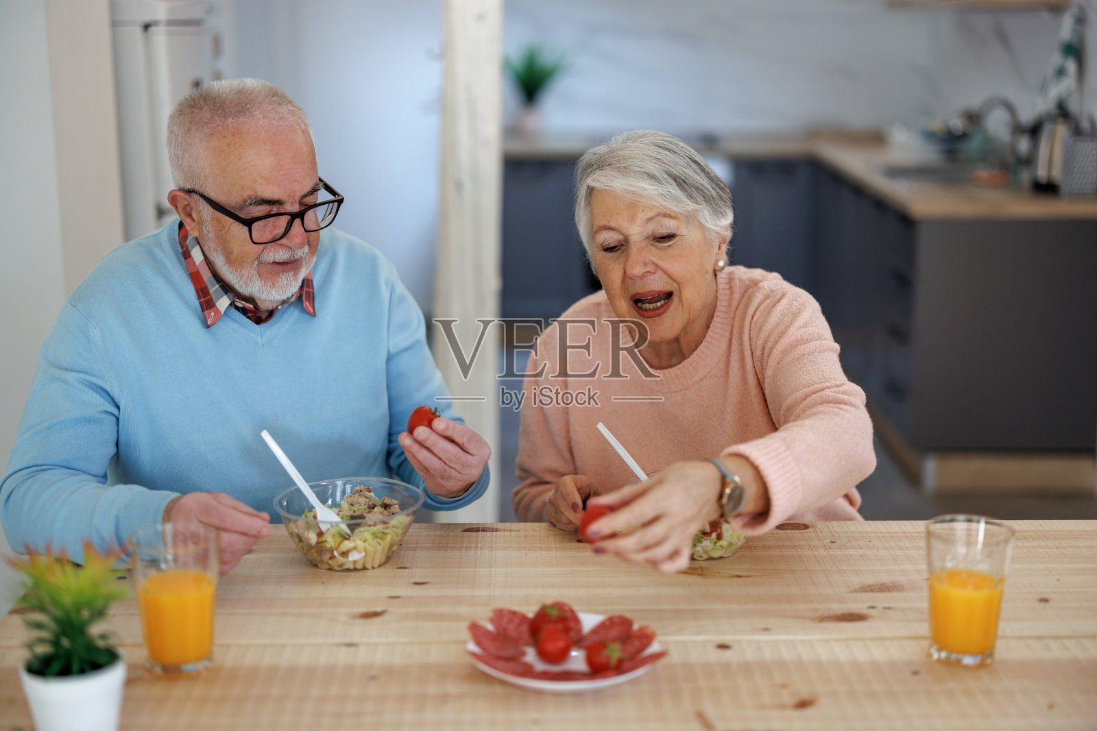 退休老年夫妇生活方式生活理念。老夫妇喜欢在厨房一起吃健康的早餐。退休夫妇的概念照片摄影图片
