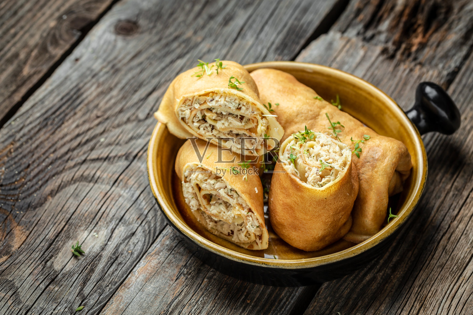 木制背景上有鸡肉和奶酪的填充煎饼或薄饼卷。传统的Maslenitsa节日大餐。前视图。文本的地方照片摄影图片