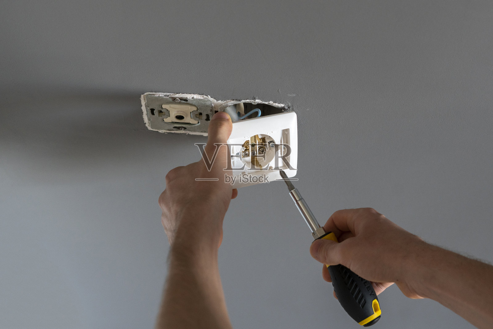 在家修理墙上的电源插座照片摄影图片