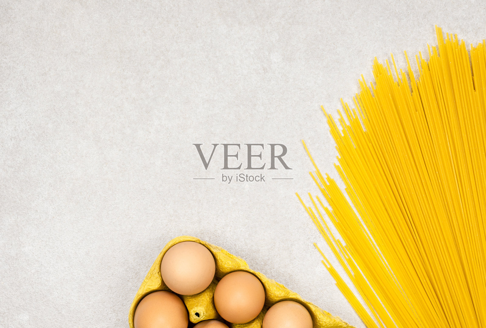黄色的面条面条与鸡蛋在灰色的背景与复制空间照片摄影图片