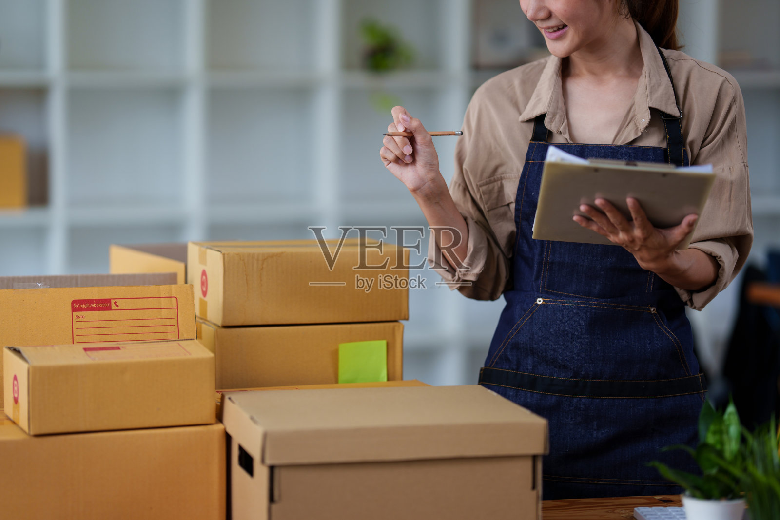 近距离亚洲妇女，电子商务员工自由与包裹盒送货到客户。网上营销包装箱配送理念。照片摄影图片