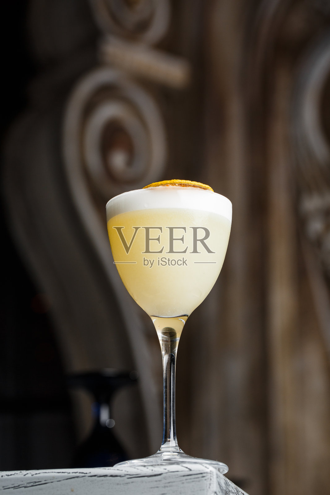 玻璃黄柠檬鸡尾酒装饰干柠檬片在酒吧柜台背景模糊照片摄影图片