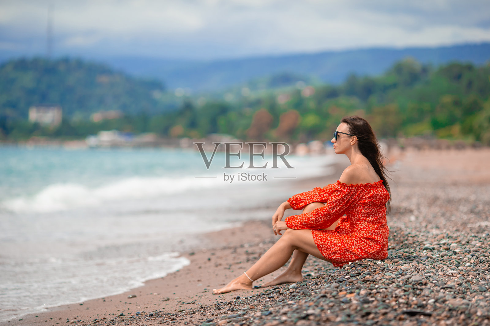 年轻快乐的女人在海滩上与山景照片摄影图片