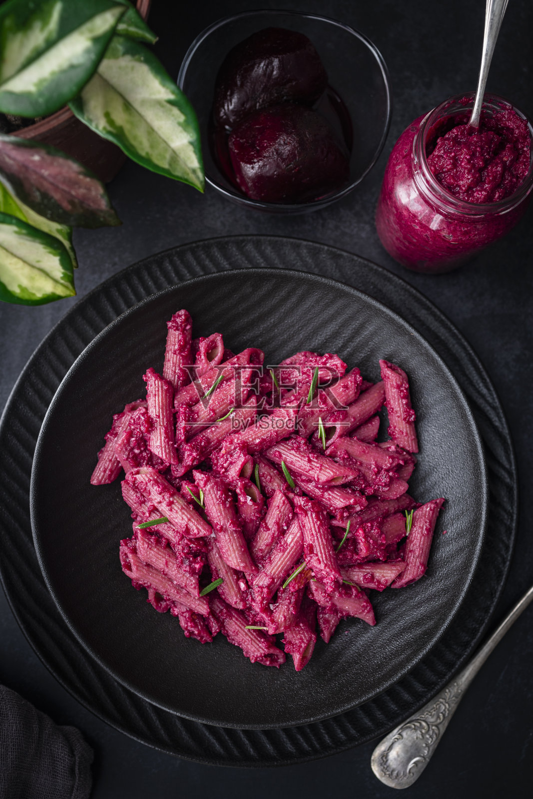 粉色甜菜根香蒜酱意大利面。通心粉配粉色甜菜根香蒜酱。照片摄影图片